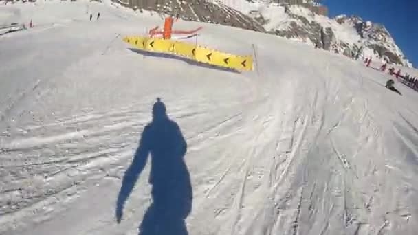 Un snowboarder desciende a la velocidad de una montaña en los Alpes — Vídeos de Stock