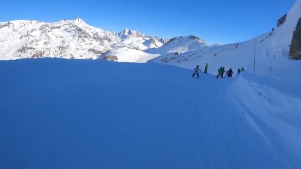 A snowboarder passes true people in the Alps — Stock Video