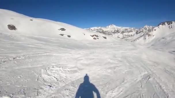 A snowboarder descends at speed from a mountainside in the Alps — Vídeo de Stock