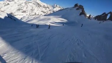 Bir snowboardcu Alplerdeki bir dağ yamacından hızla iner.
