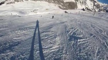 Bir snowboardcu Alplerdeki bir dağ yamacından hızla iner.