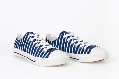 Pair of new, trendy striped navy blue and white sneakers on white background.