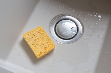 Mutfağın dibindeki sarı sentetik sünger.