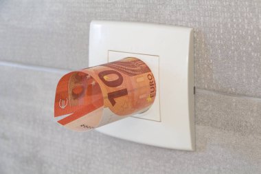 Elektrik fiyatını sembolize etmek için bir soketteki avro banknotu