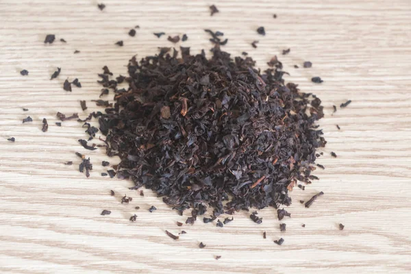 Tahta Arka Planda Yasemin Aromalı Siyah Çay Yaprakları — Stok fotoğraf