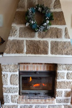 Oturma odasına Noel çelengi takılmış şömine.