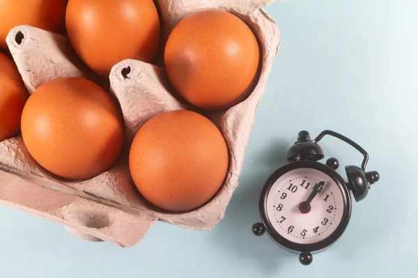 Telur Ayam Dalam Karton Telur Dan Jam Alarm Hitam Stok Gambar