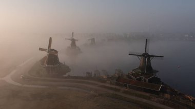 Zaanse Schans 'ın sisli sabahında eski güzel yel değirmenleri