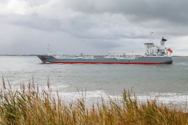 Deniz bulutlu bir günde kargo gemisinin manzaralı görüntüsü.