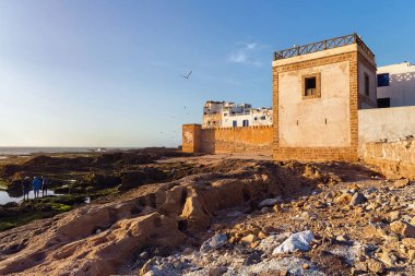 ESSAOUIRA, MOROCCO - 08 Haziran 2017 'de Fas' taki Atlas Okyanusu 'nun tarihi surları ve volkanik kıyılarının alçak gelgit zamanında bir yaz akşamı görüntüsü.