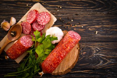 Sosisli salam, arka planda baharatlar.