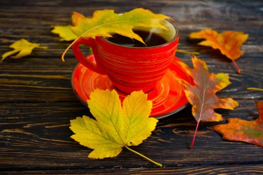 Kahve fincanı. Ahşap arka planda sonbahar yaprağı.