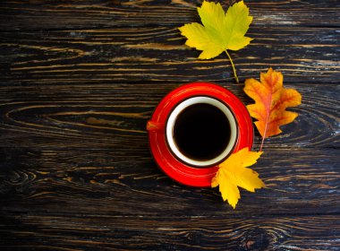 Kahve fincanı. Ahşap arka planda sonbahar yaprağı.