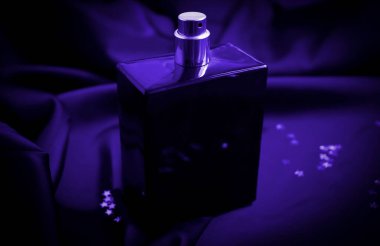 İpek arka planda bir şişe parfüm.