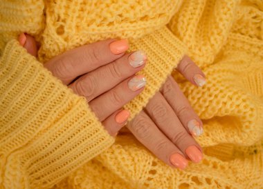Kadın elleri güzel manikür sıcak kumaş süveter sarısı