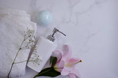 Banyo aksesuarları, mermer arka planda çiçekler.