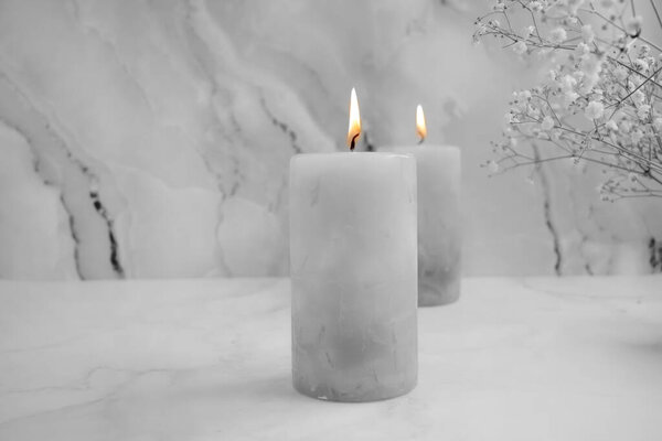 candle, gypsophila flower on a concrete background