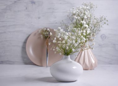 Boş tabak, vazolar, tahta arka planda çingene çiçeği.