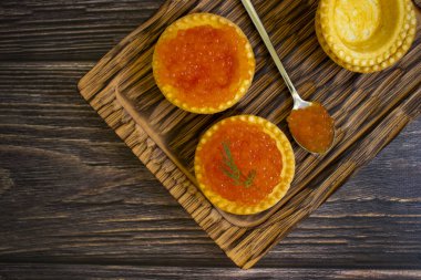 Tahta arka planda turtada kırmızı havyar.