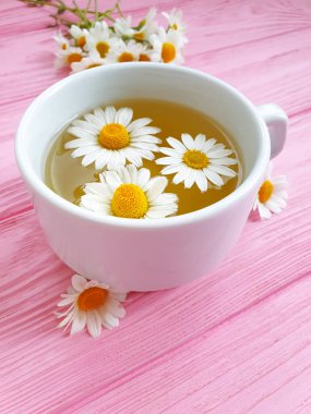 Ahşap arka planda papatya çayı fincanı