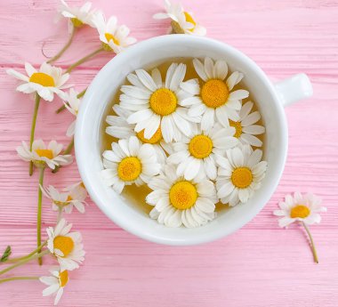 Ahşap arka planda papatya çayı fincanı