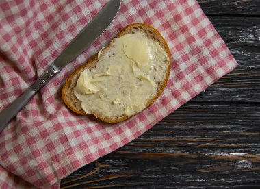 Tahta arka planda tereyağlı ekmek