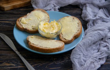 Tahta arka planda tereyağlı ekmek