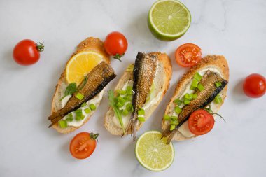 sprats in a can, fresh dill on wooden background