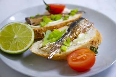 sprats in a can, fresh dill on wooden background