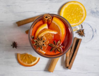 Sıcak şarap bardağı, ahşap arka planda limon.