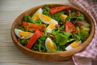 yeşil salata, yumurta, ahşap arka planda bir tabakta domates