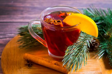 Sıcak şarap bardağı, ahşap arka planda limon.