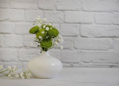 çingene çiçeği, bir vazoda krizantem tuğla arka planda.