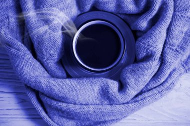 Kahve fincanı, ahşap arka planda sıcak bez.