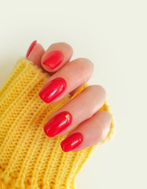 Güzel kırmızı manikür kadın eli, sarı kazak