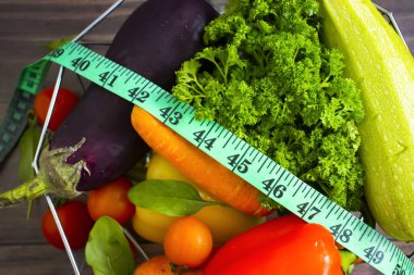 Taze sebzeler, ahşap arka planda mezura.