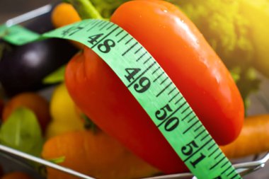 Taze sebzeler, ahşap arka planda mezura.