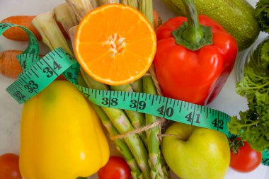 Taze sebzeler, ahşap arka planda mezura.