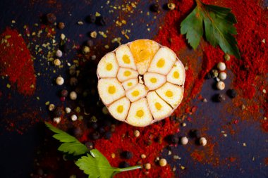 Farklı baharatlar, koyu arkaplanda sarımsak.