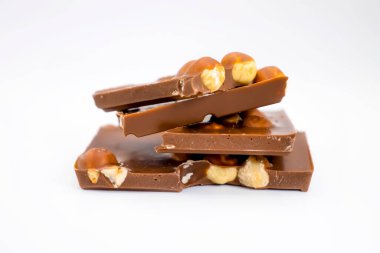 Beyaz arka planda fındıklı çikolata parçaları.