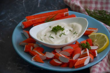 Yengeç sopaları, ahşap arka planda bir tabakta sos.