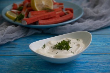 Yengeç sopaları, ahşap arka planda bir tabakta sos.