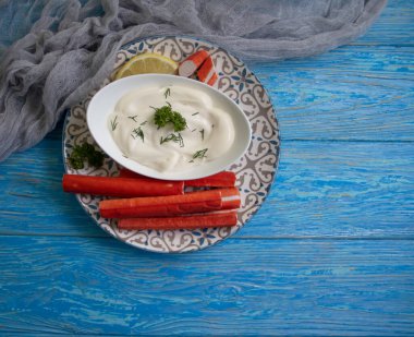 Yengeç sopaları, ahşap arka planda bir tabakta sos.