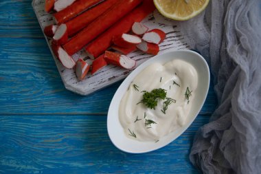 Yengeç sopaları, ahşap arka planda bir tabakta sos.