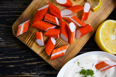 Yengeç sopaları, ahşap arka planda bir tabakta sos.