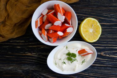 Yengeç sopaları, ahşap arka planda bir tabakta sos.