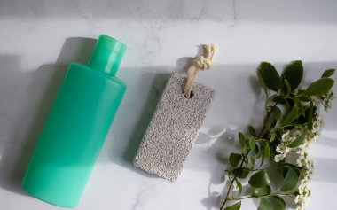 Ayaklar için sünger taşı, çiçek, arka planda krema