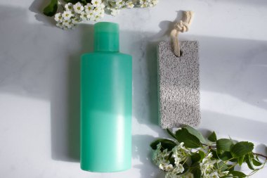 Ayaklar için sünger taşı, çiçek, arka planda krema