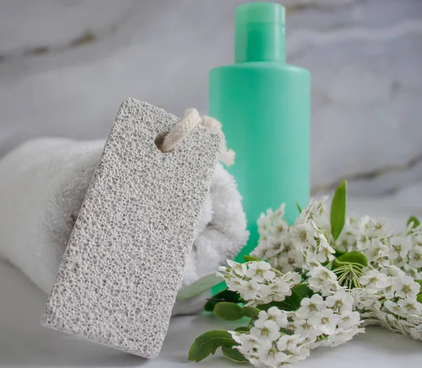 pumice for feet, towel, flower, soap on a light background