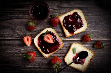 Eski bir arka planda bir bardak ekmeğin içinde çilek reçeli